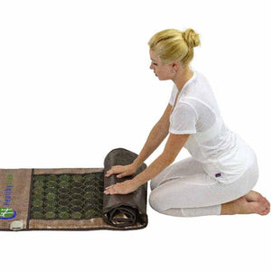 Woman kneeling and rolling up a HealthyLine gemstone mat