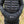 Person wearing a black Savior branded hand warmer muff over a black puffer jacket