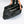 Person packing a Snow Peak storage bag with metal camping equipment
