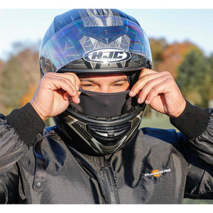 Person wearing a California Heat jacket and HJC helmet adjusting a black face mask