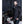 Man with beard wearing a black windbreaker jacket standing next to a motorcycle