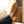 Acorn tan suede slip on slippers worn on feet resting on a couch