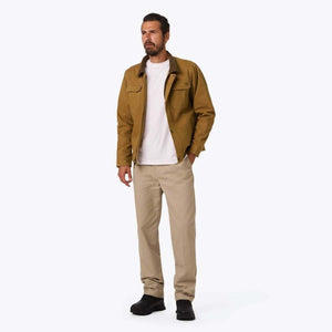 Man wearing a brown Mobile Warming canvas jacket over a white t-shirt and khaki pants