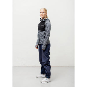 Woman wearing a grey and black Heat Experience hooded jacket and blue trousers