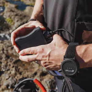 Person holding a Venture Heat battery pack connected to a wrist mounted controller