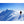 Climber in Dr Warm gear standing on a snow covered mountain ridge above clouds