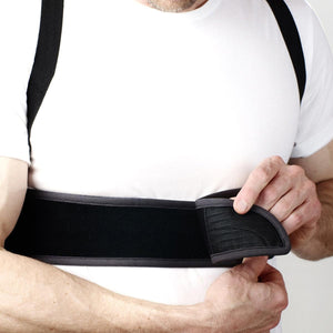 Person adjusting Oro Sports black back support brace over white t-shirt
