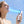 AlphaCool handheld fan blowing air on a person with a digital display showing battery percentage