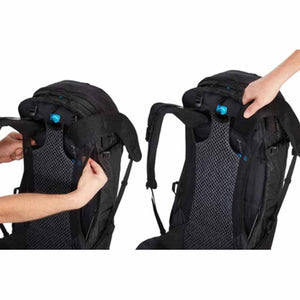 Hands adjusting the adjustable torso length on a black Thule hiking backpack