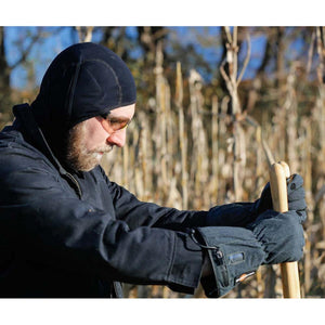 Man wearing California Heat black balaclava and gloves holding a shovel outdoors