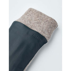 Hestra glove cuff featuring dark blue leather and a beige ribbed wool knit trim