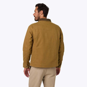 Back view of a man wearing a tan Mobile Warming canvas jacket with a dark collar