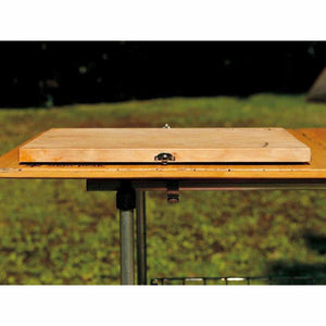 Snow Peak folding wooden cutting board closed on a camping table