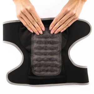 Hands holding a black back support brace with a mesh center panel