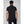 Back view of a man wearing a black Helly Hansen polo shirt with dark blue jeans