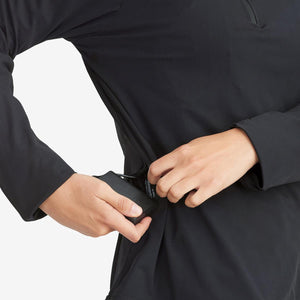 Person inserting a portable battery pack into a side pocket of a black long sleeve shirt
