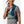 Person wearing a blue Nathan hydration vest and placing an energy gel into the front pocket