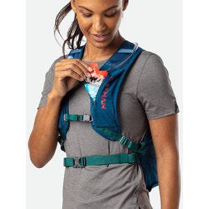 Person wearing a blue Nathan hydration vest and placing an energy gel into the front pocket