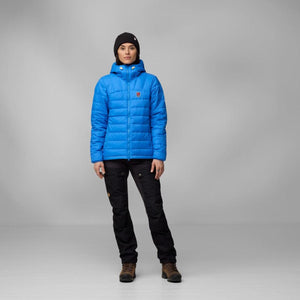 Person wearing a blue FjallRaven hooded down jacket and black trousers