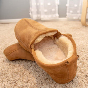 Acorn tan suede slippers with cream faux fur lining on carpet