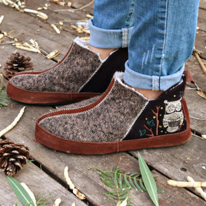 Acorn slipper with brown wool texture and owl embroidery on a wooden surface