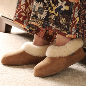Acorn tan suede slippers with cream faux fur lining worn with a patterned skirt