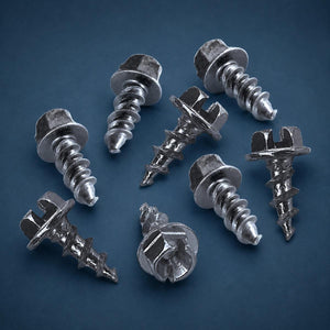 Group of seven metal screws with hex heads on a dark blue background