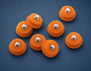 Action Traction orange rubber studs with metal centers on a blue background