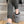 Person wearing grey ActionHeat cable knit slippers while sitting on carpeted stairs