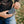 Person connecting a portable ActionHeat battery pack to a heated garment
