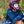 Person wearing ActionHeat black long sleeve shirt and gloves with a red motocross helmet leaning on a dirt bike