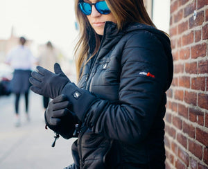 Person wearing ActionHeat black gloves and a black jacket outdoors