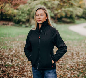 Woman wearing a black ActionHeat heated softshell jacket outdoors