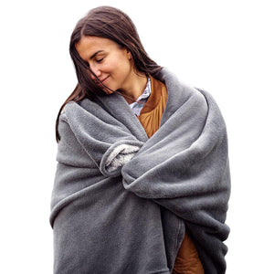 Woman wrapped in a grey ActionHeat fleece blanket