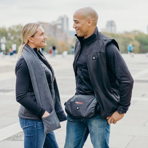 Man and woman wearing ActionHeat black heated vests and accessories outdoors