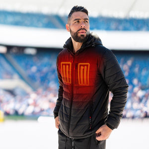 Man wearing a black ActionHeat heated jacket with visible glowing red heating elements on the chest