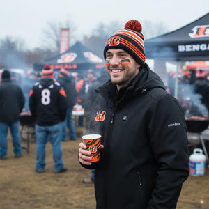 Man wearing ActionHeat jacket and Bengals beanie holding a branded paper cup at a tailgate