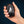 Hand holding a black ActionHeat rechargeable hand warmer with three red LED indicator lights