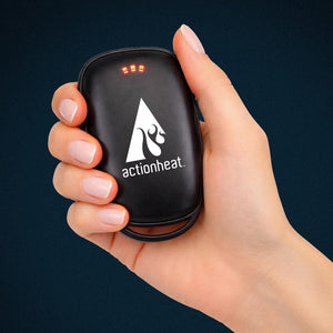 Hand holding a black ActionHeat rechargeable hand warmer with three red LED indicator lights