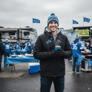 Man wearing ActionHeat jacket and Detroit Lions beanie holding a steaming mug at a tailgate