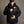 Man wearing a black Green Bay Packers hooded puffer jacket with team logo on chest