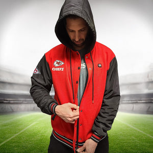 Man wearing a red and black ActionHeat Kansas City Chiefs hooded varsity jacket on a football field