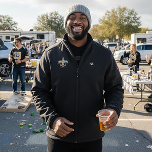 Man wearing a black ActionHeat jacket with a New Orleans Saints logo at a tailgate party