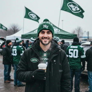 Man wearing ActionHeat jacket and New York Jets beanie holding a coffee cup in a snowy stadium parking lot