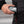 Hand placing a Philadelphia Eagles branded grey hard shell case into a black jacket pocket