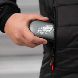 Hand placing a Philadelphia Eagles branded grey hard shell case into a black jacket pocket