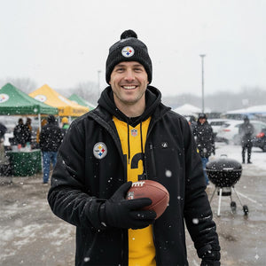 Man wearing ActionHeat jacket and Steelers gear holding a football in the snow
