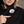 Person pressing the power button on a black ActionHeat Steelers heated jacket