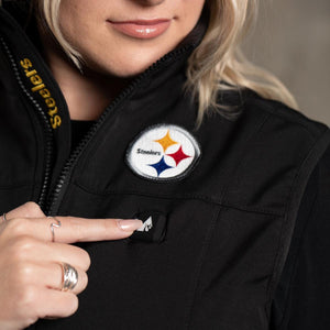 Person pressing the power button on a black ActionHeat Steelers heated jacket