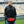 Man wearing ActionHeat black heated vest with visible heating element in front pocket at a stadium